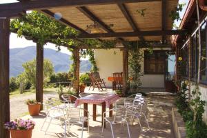 a patio with a table and chairs under a pergola at Fighezia in Fluminimaggiore
