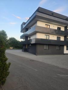 a building with a parking lot in front of it at CityVibe Apartament in Luduş