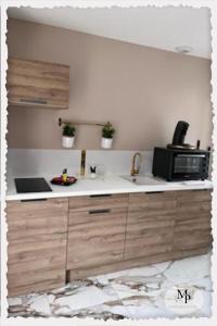 una cucina con lavello e microonde di Evasion Romantique&Jacuzzi! a Pruniers
