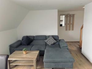 a living room with a blue couch and a table at Ferienwohnung im Hotel Preyt 35228 in Holtlander Nücke +11 photos