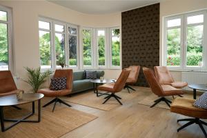 a waiting room with chairs and tables and windows at Ferienwohnung im Hotel Preyt 35228 in Holtlander Nücke