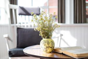 Eine Vase mit Blumen und ein Buch auf einem Tisch in der Unterkunft Vila Pervalka in Pervalka + 28 Fotos