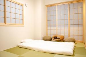 Una habitación con una cama y dos sillas. en 北宿kitayado, en Osaka