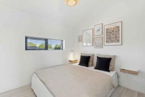 a white bedroom with a bed and a window at Modern Holiday Home On Beautiful Langeland in Humble