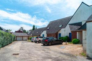 una fila de casas con coches aparcados en una entrada en Locmariaquer Mer & Plage - à 50m de la plage, en Locmariaquer