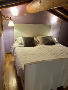 a bedroom with a large white bed with two pillows at Chalet Calcar in Avenone +54 photos