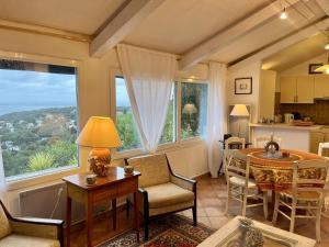 a living room with a table and chairs and a kitchen at Sete La Vigie Singuliere in Sète