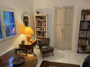 a living room with a table and chairs and bookshelves at Sete La Vigie Singuliere in Sète