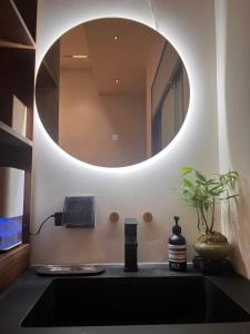上海LAYLiVE Good soundproofing Near the subway, US Consulate, Nanjing Road Jing'an Temple business district Convenient transportation Courtyard music的浴室水槽和上面的圆镜子 更多20张照片