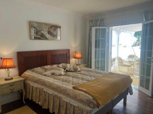 a bedroom with a bed with two lamps and a balcony at Schönes Apartment - ruhig - Aussenpool in La Orotava +5 photos