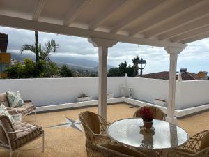 a patio with a table and chairs on a balcony at Schönes Apartment - ruhig - Aussenpool in La Orotava