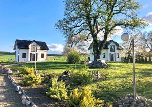 una casa bianca in mezzo a un campo di Nuka House - Teatr Natury z Jacuzzi a Łąka Prudnicka