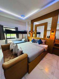 a bedroom with a large bed and a mirror at Baanmeesuk Pool Villa Pattaya in Jomtien Beach