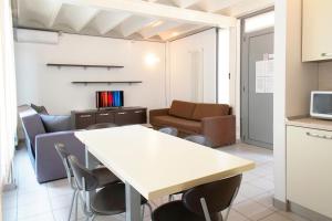 a room with a table and chairs and a couch at Appartamenti tra Lago e Montagna CASA IDEALE LECCO in Lecco
