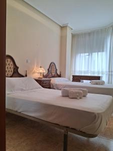 a bedroom with two beds with towels on them at R2R - Apartamento en Noja 2 dormitorios - C18A02 in Noja +27 photos