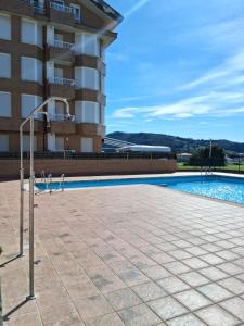 a swimming pool in front of a building at Apartamento en Noja 2 dormitorios C18A02 in Noja