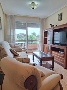 a living room with two couches and a flat screen tv at R2R - Apartamento en Noja 2 dormitorios - C18A02 in Noja