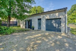 a garage building with a large garage door at La belle escapade-6 personnes- piscine in Puymoyen