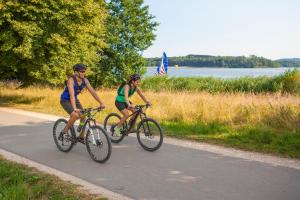 two people riding bikes down a road at Hotel Seerose Garni in Nohfelden