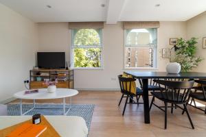 a living room with a table and chairs at 2 bedroom apartment in London Bridge in London