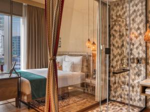 a hotel room with a bed and a shower at 25hours Hotel Dubai One Central in Dubai
