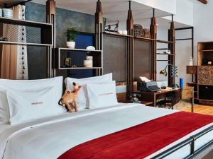 a bedroom with a bed with a dog standing on the pillows at 25hours Hotel Dubai One Central in Dubai