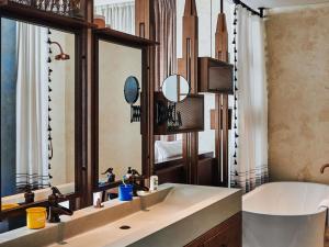 a bathroom with a sink and a large mirror at 25hours Hotel Dubai One Central in Dubai