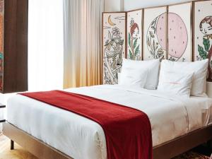 a bedroom with a large bed with a red blanket on it at 25hours Hotel Dubai One Central in Dubai