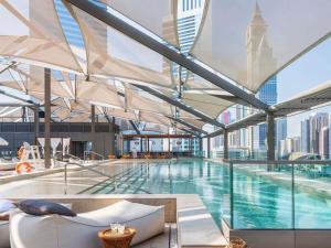 a large swimming pool with a view of the city at 25hours Hotel Dubai One Central in Dubai
