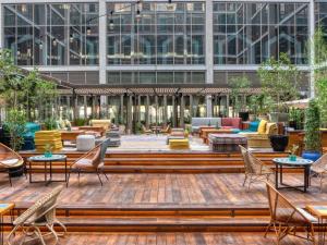 an outdoor patio with chairs and tables and a building at 25hours Hotel Dubai One Central in Dubai