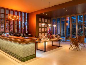 a restaurant with a bar with a table and chairs at 25hours Hotel Dubai One Central in Dubai