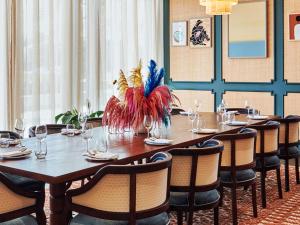 a dining room with a table and chairs with a centerpiece at 25hours Hotel Dubai One Central in Dubai
