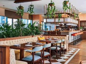 a restaurant with tables and chairs and plants at 25hours Hotel Dubai One Central in Dubai