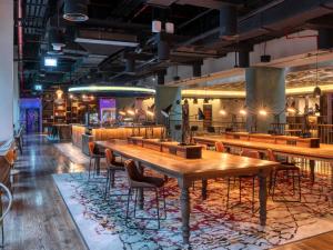 a restaurant with a wooden table and chairs at 25hours Hotel Dubai One Central in Dubai