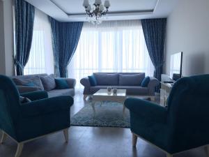 a living room with two blue couches and a table at Fursan Apart My Doğa in Trabzon