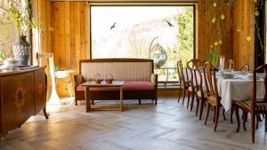 a dining room with a table and chairs and a large window at Dom w Dolinie Zdrowia in Wleń