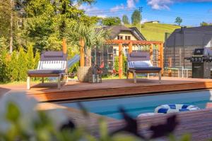 two chairs sitting on a deck next to a swimming pool at Chata Dwie Doliny in Muszyna