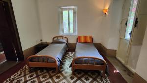 two beds in a small room with a window at Agriturismo Boccadifuoco sul Fiume Alcantara in Motta Camastra +110 photos