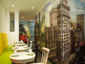 a row of tables in a restaurant with a mural at Hôtel du Continent in Paris