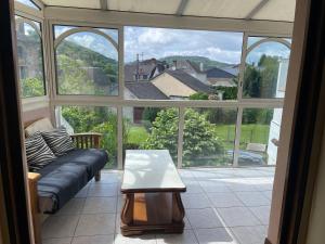 a living room with a couch and a large window at Maison au cœur de ville in Bort-les-Orgues