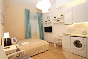 um pequeno quarto com uma cama e uma máquina de lavar roupa em TVST Apartment Nizhnaya em Moscou