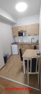 a kitchen with a wooden table and a table and chairs at PrzyLądek 30 in Lądek-Zdrój +19 photos