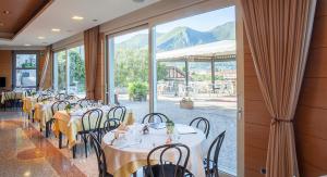 a dining room with tables and chairs and a large window at Locanda del Lago Rosmunda in Clusane sul Lago