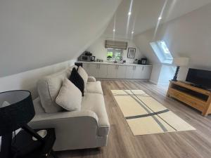 a living room with a couch and a tv and a kitchen at THE STUDIO - Silverstone village - walking distance to track in Silverstone
