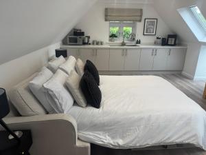 a bedroom with a large white bed with pillows at THE STUDIO - Silverstone village - walking distance to track in Silverstone
