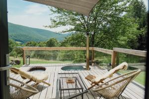 eine Terrasse mit zwei Stühlen und einem Tisch sowie ein Pool in der Unterkunft Humno in Nová Baňa