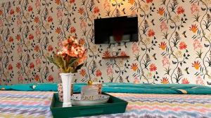 a room with a bed with a vase of flowers on a table at Peaceful Studios in Assagao in Parra