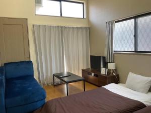a bedroom with a bed and a blue chair at エスポアール新町103 in Kumamoto