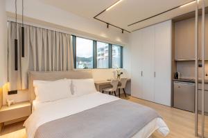 a bedroom with a bed and a desk and a kitchen at Xanthia Suites in Xanthi