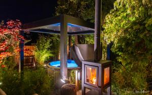 a fire place in a garden with a table at Le Jardin Secret in Waterloo